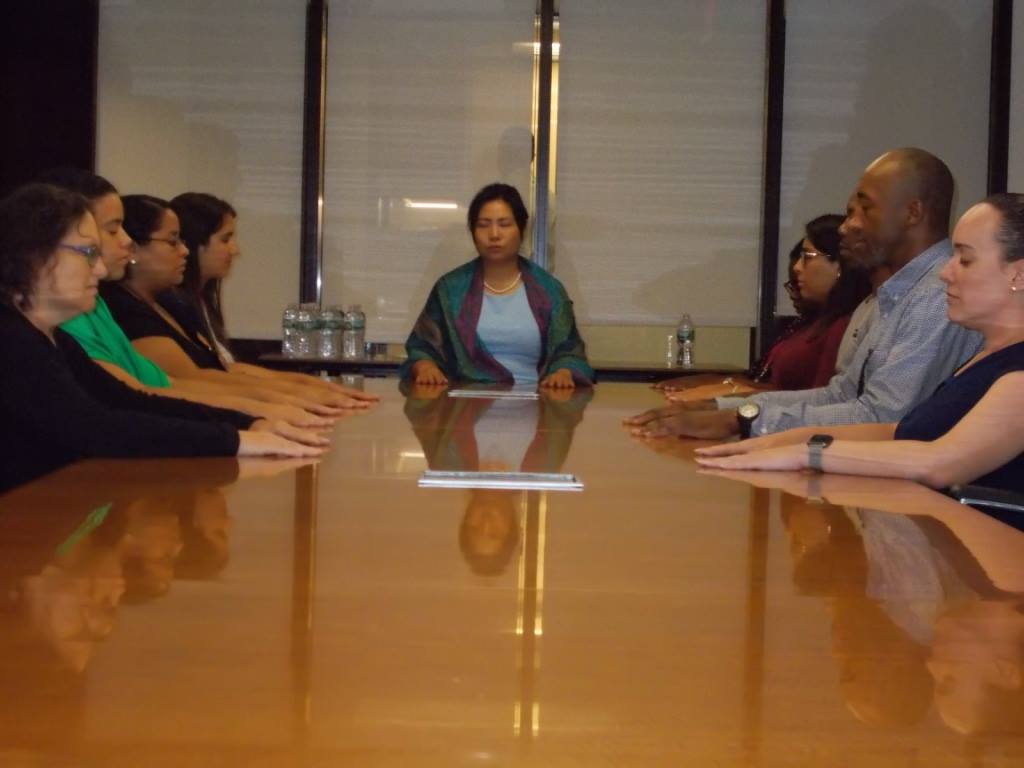 Nandar Matari leading a meditation for lawyers and paralegals around the boardroom table at Tarter Krinsky and Drogin